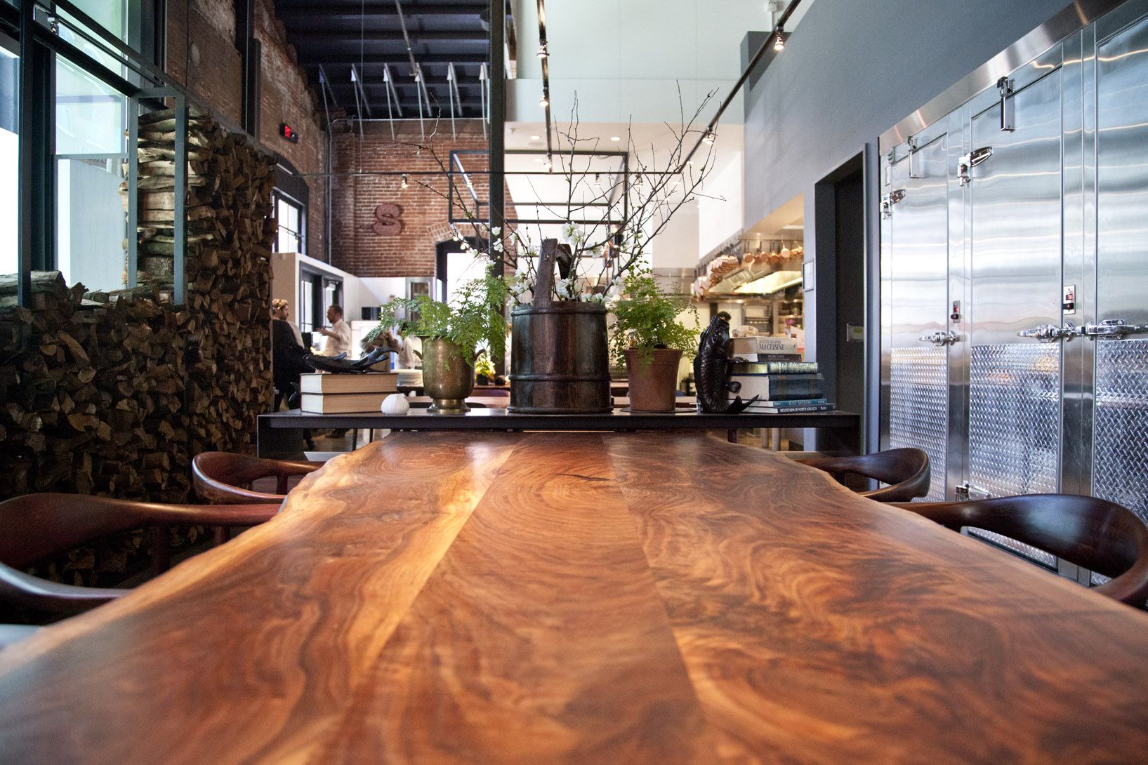 A long reclaimed walnut dining table by Original Timber Co. at Saison, San Francisco